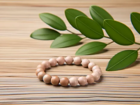 Vòng tay gỗ dâu tằm được đặt trên bàn gỗ, hòa quyện với thiên nhiên.